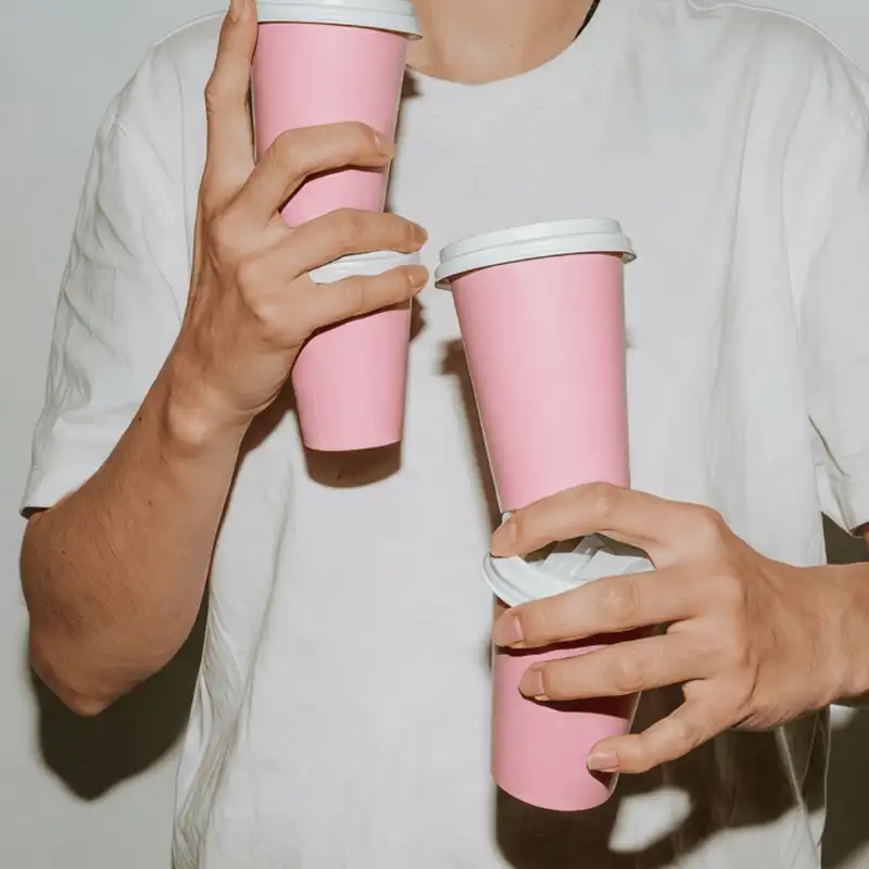 Animación de la identidad de Blue Miau: una persona con dos vasos rosados de la marca