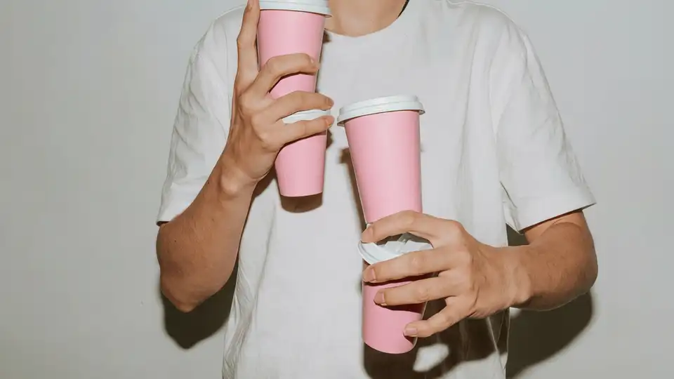 Animación de Blue Miau: una persona sosteniendo dos vasos rosados de la marca